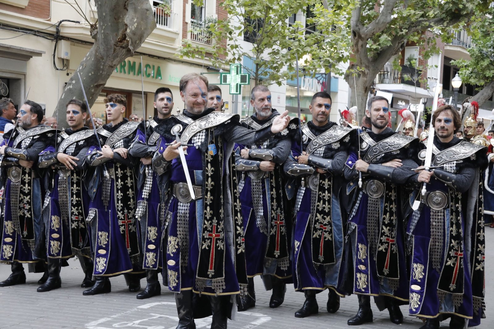 Fila de participantes con vestimenta ceremonial en el desfile oficial